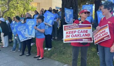 Staff and family members of patients at UCSF Benioff Children's Hospital Oakland in Oakland, Calif., hold signs during a rally on Thursday, July 9, 2026. Rally participants protested the relocation of specialized care clinics to the hospital's San Francisco campus. Photo by Kayla Chan/Bay City News.