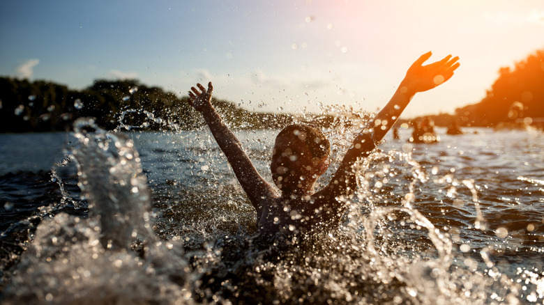 Child splashes in cool waters of lake