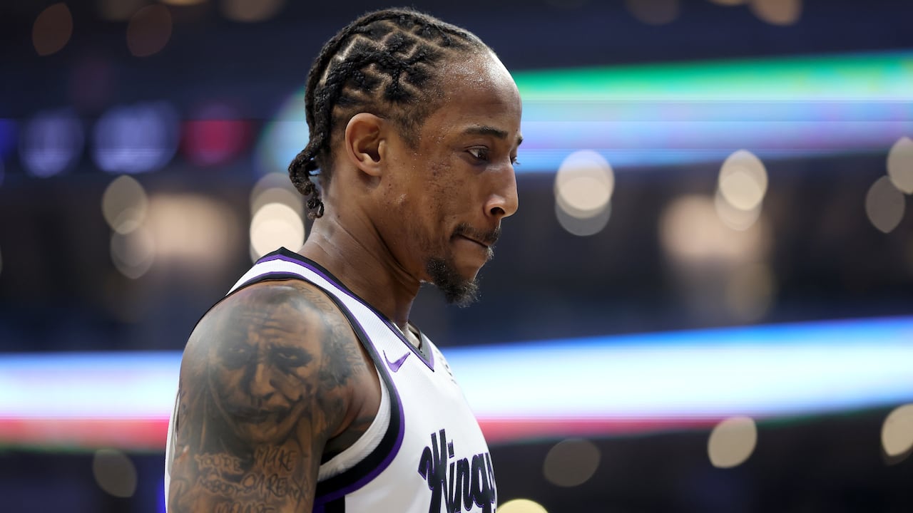 A basketball player stands sideways.