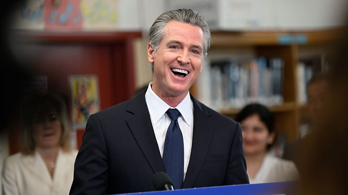 Gavin Newsom laughs in front of a crowd