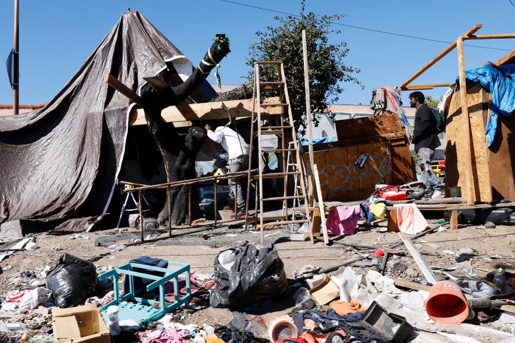 A homeless encampment in Oakland, California, made of tarps, wood, and other materials.