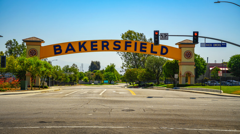 Yellow Bakersfield sign arching over road