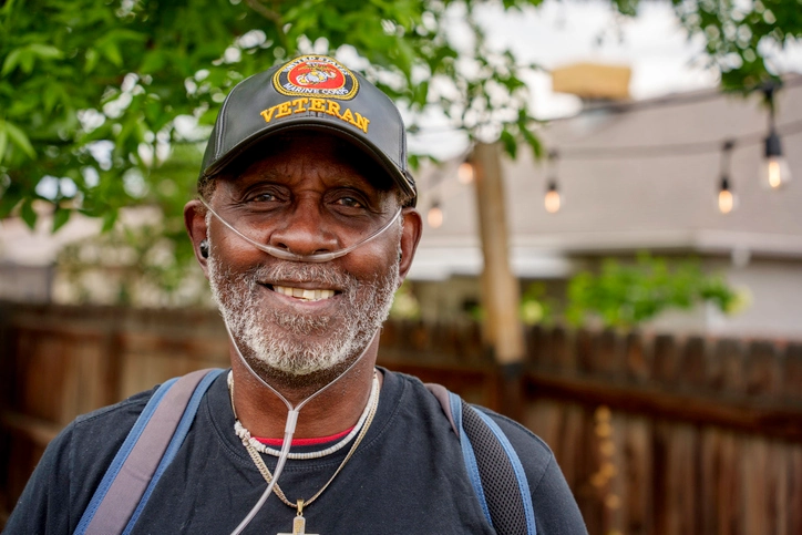 Outdoor Portrait African American Marine Veteran in His Seventies Wearing Oxygen Mask and Military Hat