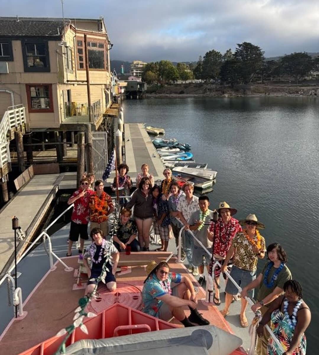 Alameda Post - Seventeen Sea Scouts pose of the front of a boat while the camera person stands above them on a boat.