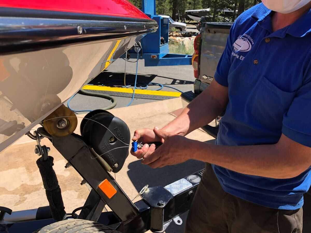 A Lake Tahoe watercraft inspector applies an inspection seal to a boat that has been inspected and decontaminated at Lake Tahoe. Authorities have intercepted six watercraft this summer that allegedly attempted to launch on the lake with tampered inspection seals as officials work to keep invasive golden mussels and other aquatic invasive species out of Lake Tahoe.