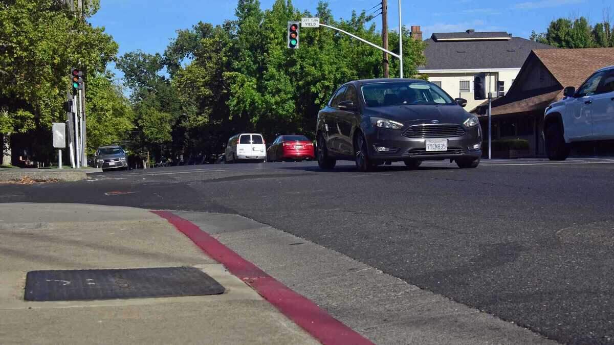 A painted red curb marks a no parking zone near the intersection of 39th and J streets in East Sacramento on Tuesday, July 21, 2026. Sacramento is painting some curbs to help drivers identify parking restrictions under California's daylighting law, even though the markings are not required and the city says funding limits how quickly affected intersections can be marked.