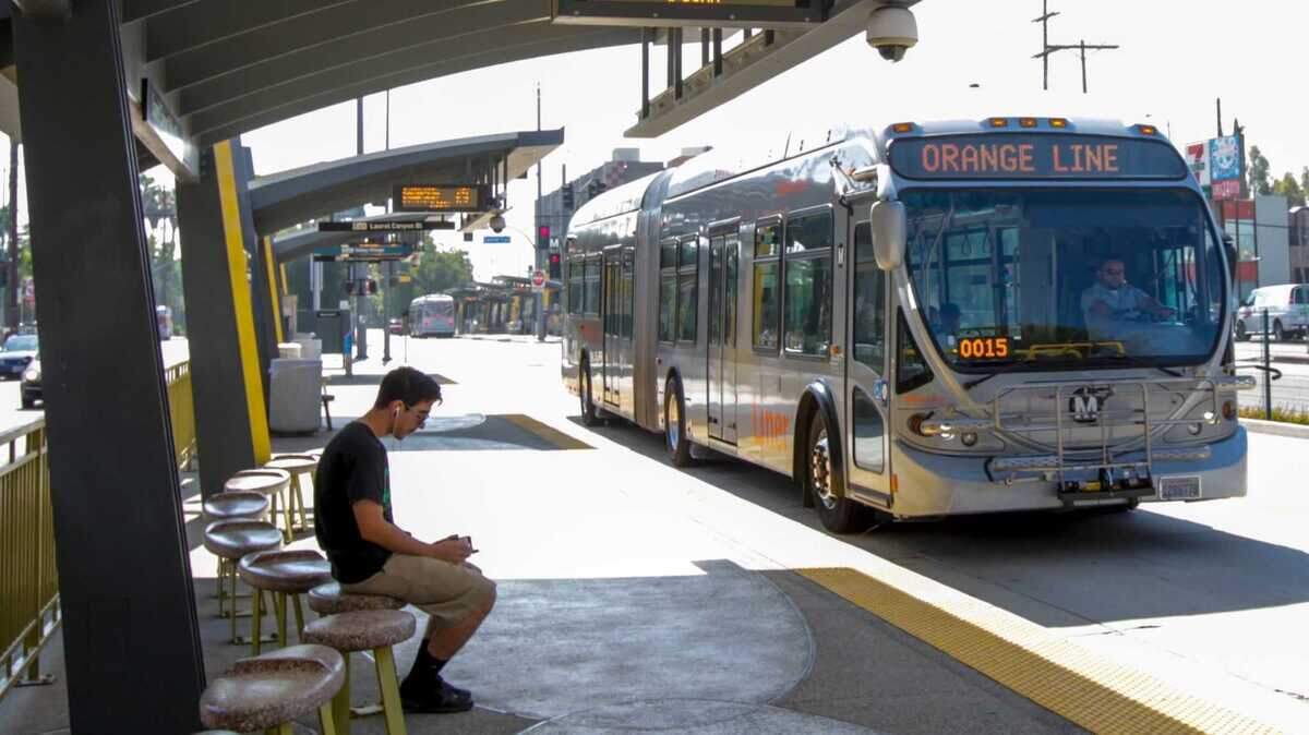 A passenger waits to board a Metro G Line bus at the North Hollywood station in Los Angeles in 2017. The line is one of California's best-known examples of bus rapid transit, the type of service Sacramento Regional Transit is studying for a future connection to Sacramento International Airport.
