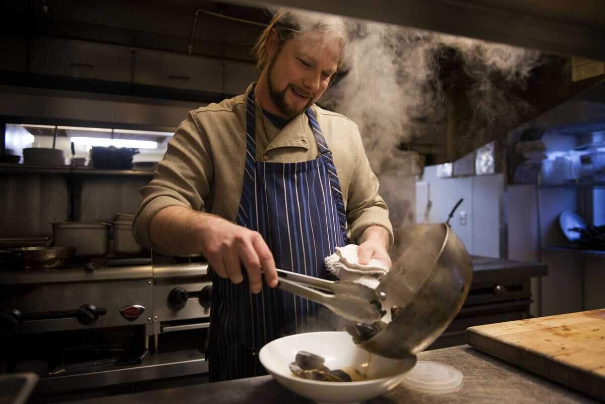 Adam Pechal, then executive chef and co-owner of Tuli Bistro and Restaurant Thir13en, pours sauteed mussels into a serving bowl at Thir13en in Sacramento in 2013. Pechal, 50, was arrested early Thursday on suspicion of felony domestic violence, according to the Sacramento County Sheriff’s Office.