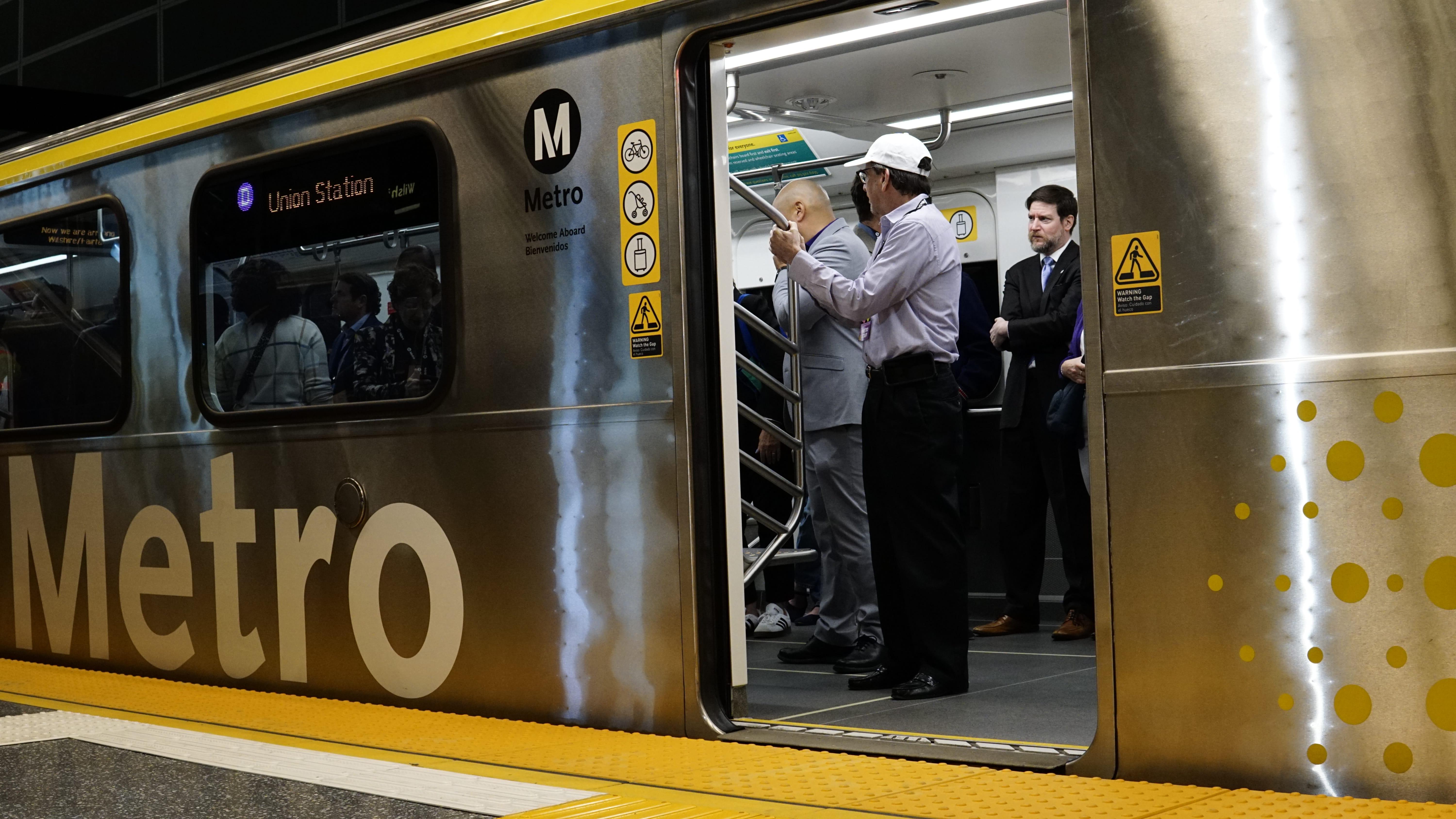 People stand inside a subway car