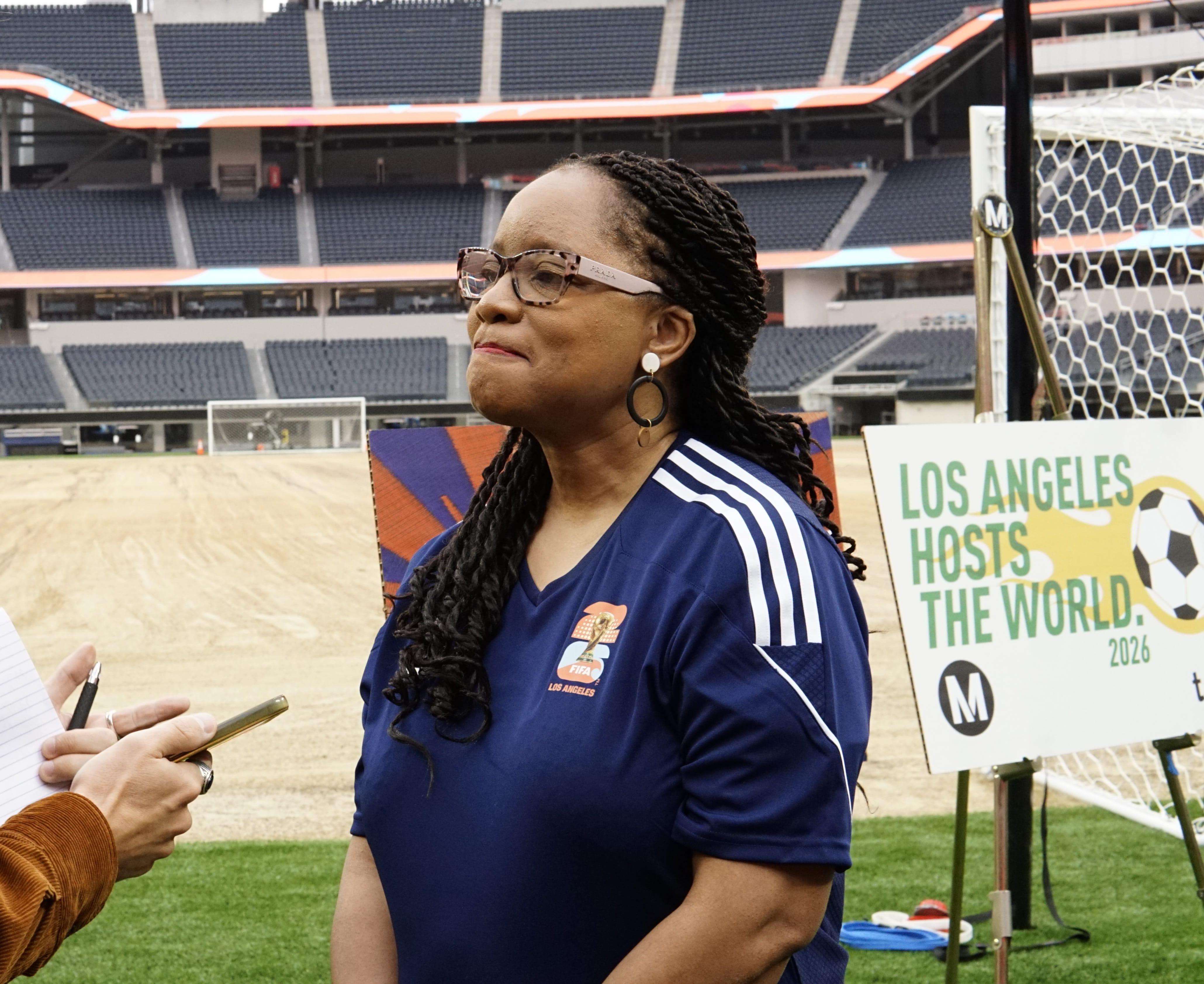 A woman stands in a soccer stadium