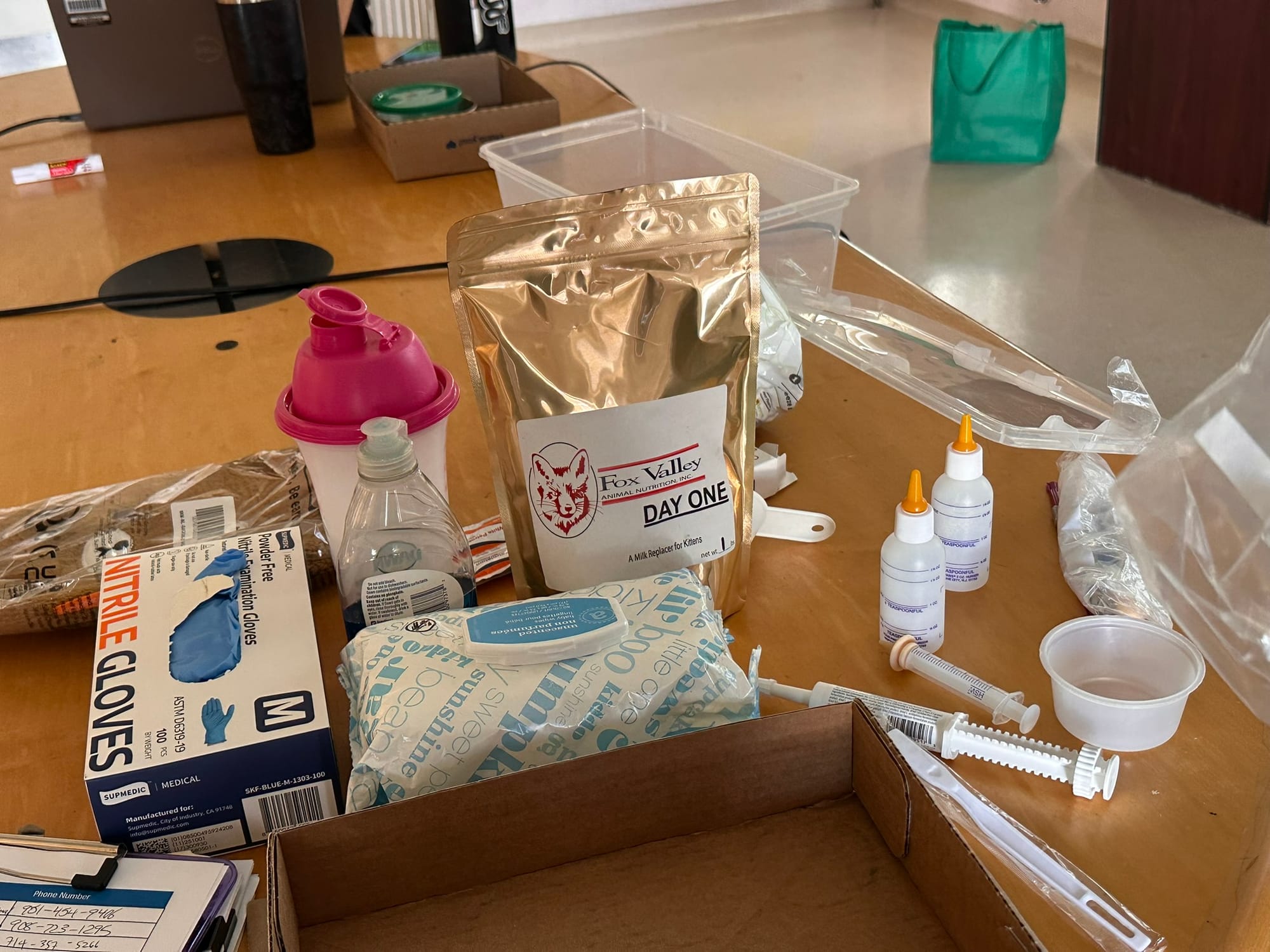 Assorted gloves, syringes and other medical items sit on a table.