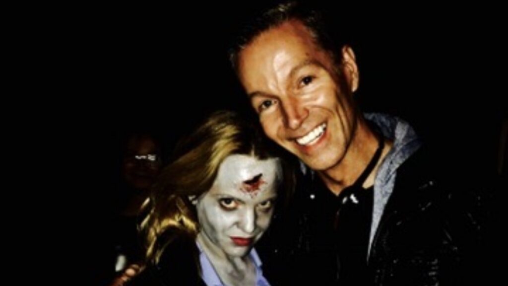 A man hugs a woman with horror makeup