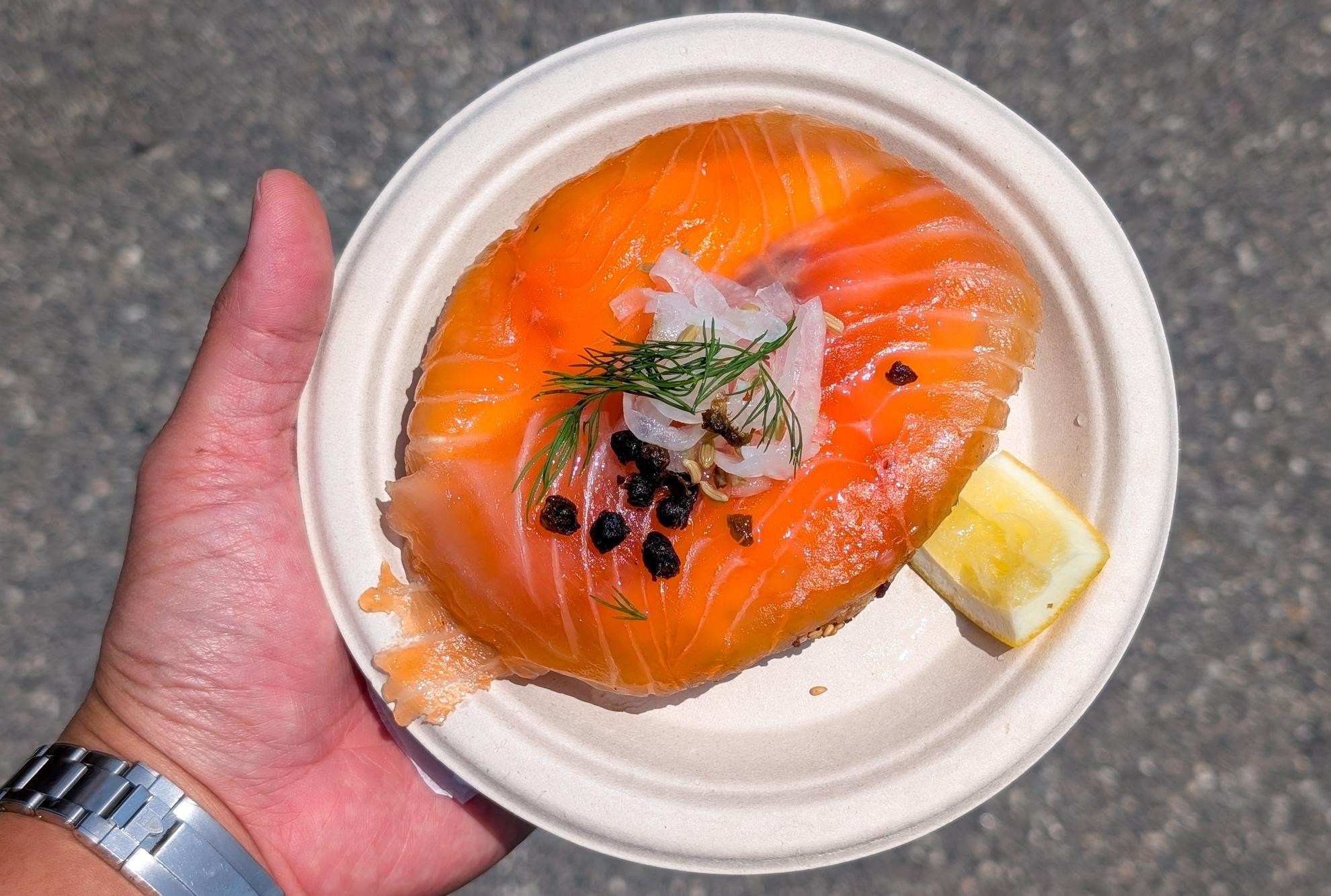 Hand holding lox bagel from Mustard’s.