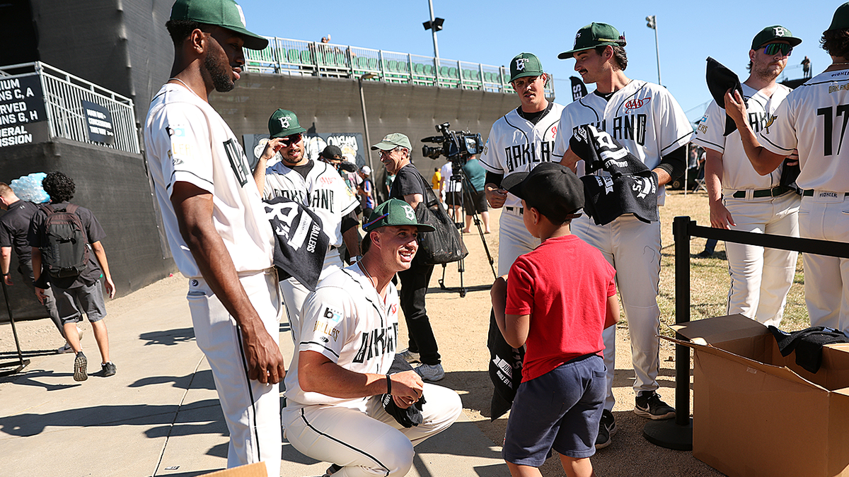 Oakland Ballers players greet young fan