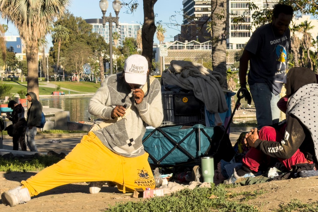 People huddled and smoking in MacArthur Park.