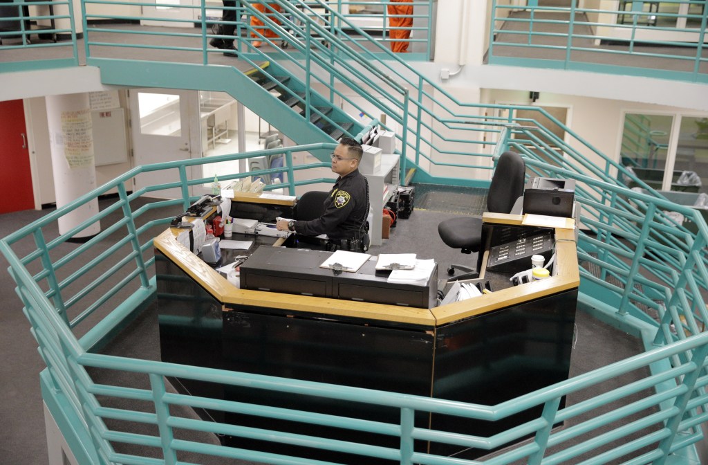 A sheriff's deputy observes female inmates from a central platform in County Jail #2.