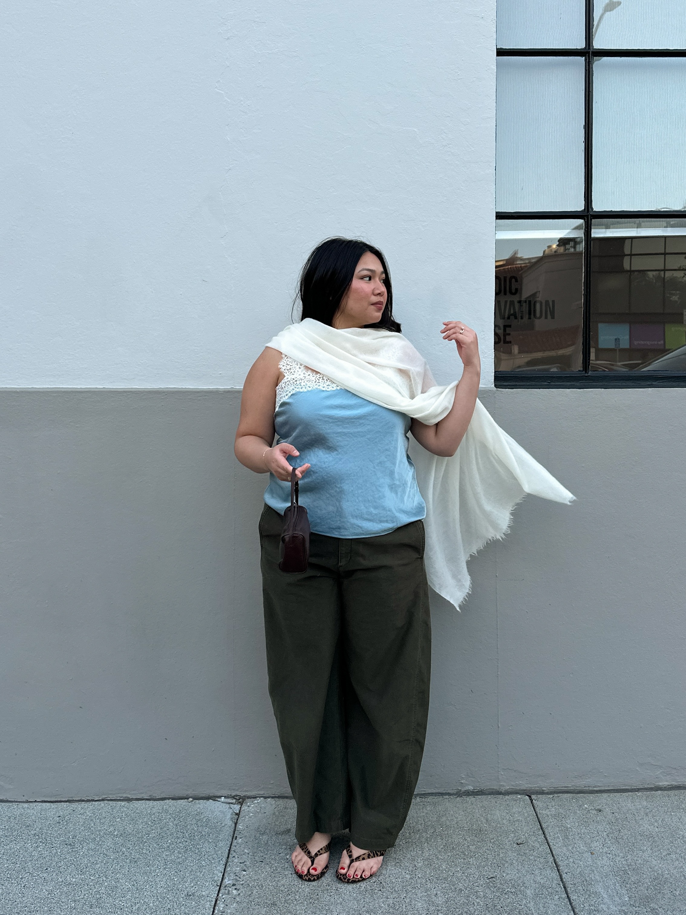 Marina in trousers, flip-flops, lace-trim top and scarf