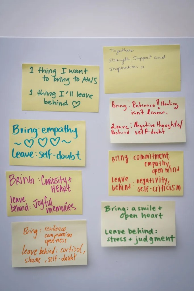 Signs of support for all gender and sexual identities can be found around San Francisco Asian Women’s Shelter offices. Reflections from a meeting are displayed at the SF Asian Women’s Shelter office space in San Francisco, California on May 27, 2026. (Sarahbeth Maney for The 19th)