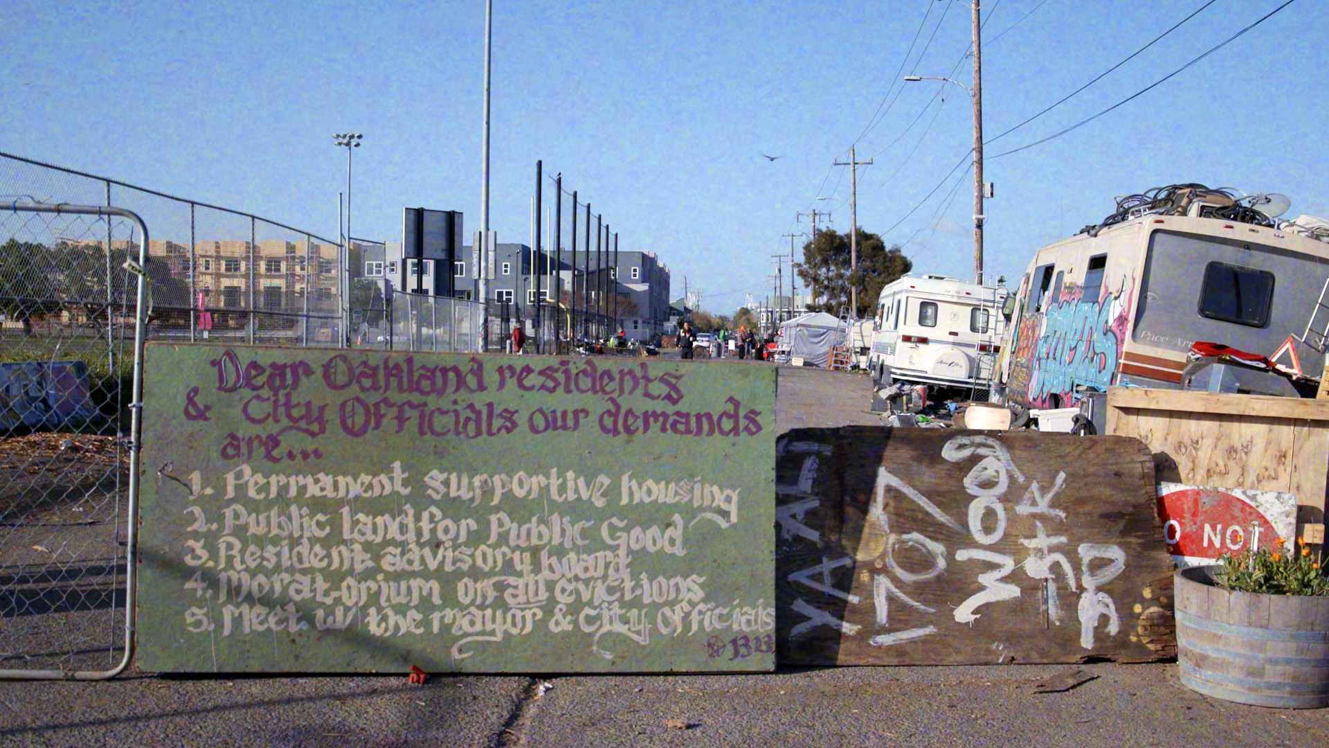 A sign outside the Wood Street encampment reads: "Permanent and supportive housing, public land for public good, resident advisory board, moratorium on all evictions, meet with the mayor and city officials."
