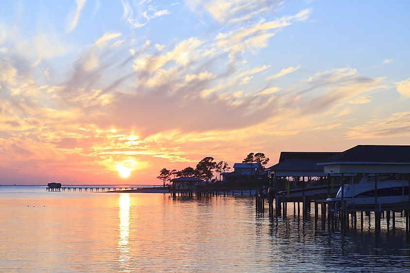 Sunset over the water and boat sheds off Gulf Breeze, Florida.