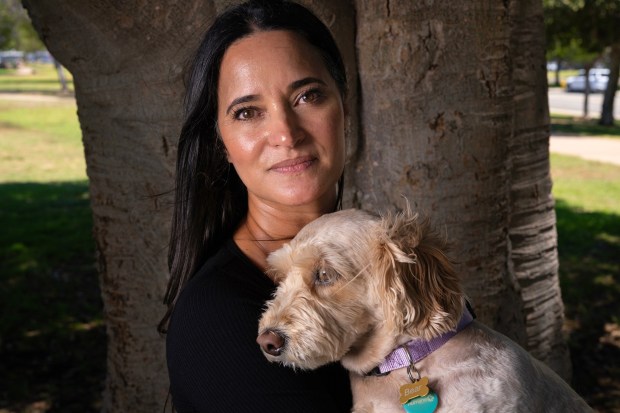 Cherie Woods and her dog Bear take a brief break from their walk near a local park not far from their home on Friday, June 12, 2026, in San Diego, CA. Woods, transitioned from a career as a sports TV producer to her current role as a special education teacher at Patrick Henry High School. (Nelvin C. Cepeda / The San Diego Union-Tribune)