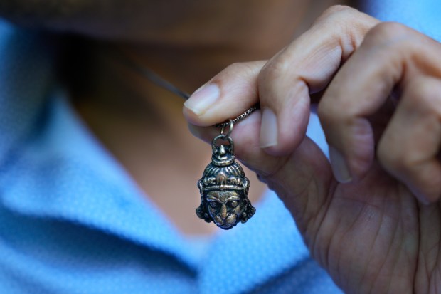 On Tuesday, June 30, 2026, Raj Aji, 64, wearing a necklace with the Hindu God Hanuman sat in the outdoor garden at Moores Cancer Center at UC San Diego. He has been receiving treatment and medication for his pancreatic cancer as part of a clinical study. Aji mentioned that since his diagnosis, he has become more focused on his life priorities. (Nelvin C. Cepeda / The San Diego Union-Tribune)