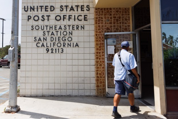 A postal worker walks into the post office in Barrio Logan on Friday, July 24, 2026. (Kristian Carreon / The San Diego Union-Tribune)