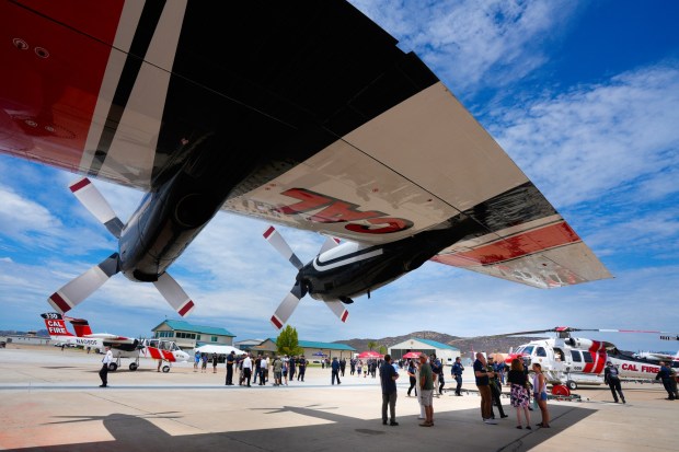 Cal Fire Chief Tony Mecham addressed the firefighters and guests during a press conference before inviting the public to take the opportunity to tour the aircraft on the flight line at Ramona Air Attack Base on Monday, July 20, 2026, in Ramona, CA.  On the left is the OV-10 Bronco, which serves as the airborne air traffic controller; the wing above is from the C-130 air tanker, and the helicopter on the left is the Sikorsky Firehawk. (Nelvin C. Cepeda / The San Diego Union-Tribune)