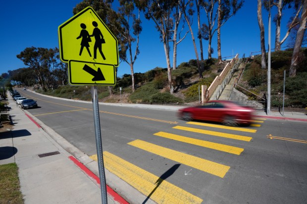 On Tuesday, July 21, 2026, a car heads up the hill on Dusk Drive, passing William Penn Elementary.  (Nelvin C. Cepeda / The San Diego Union-Tribune)