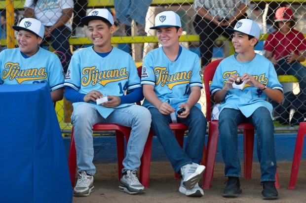 Nestor Melchor #08, Tadeo Paez #14, Matias Garcia #10, and Gael Santamaria #4 (from left to right) of the Tijuana Municipal Little League team, share a laugh during a moment of recognition and given championship rings by DarÃ­o Venegas, president of the Tijuana Municipal Children's and Youth Baseball League at the Otay baseball fields in Tijuana, Mexico on Monday, July 13, 2026. The little league team will represent Mexico for a third time during next month's Little League World Series. (Carlos Moreno / The San Diego Union-Tribune)