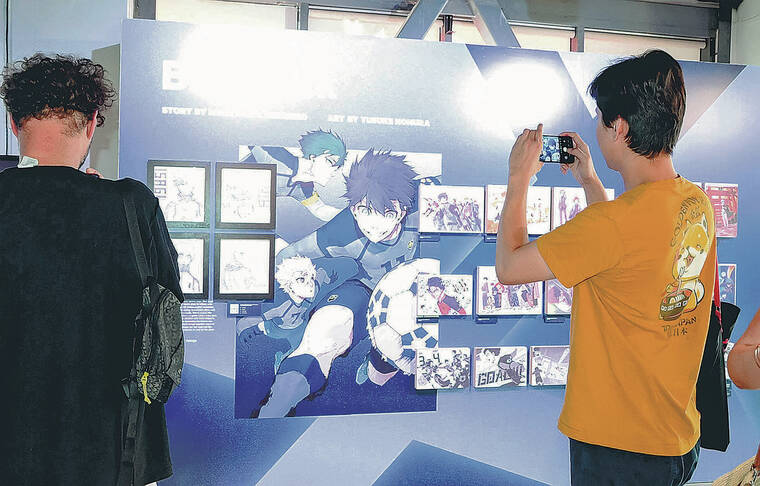 JAPAN NEWS
A visitor snaps a picture of a Blue Lock display at Kodansha House in Los Angeles. Blue Lock is a popular soccer manga.