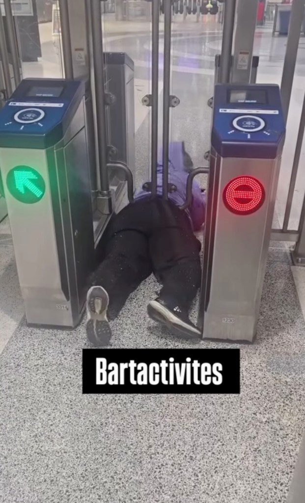 A person stuck under a BART entry gate.