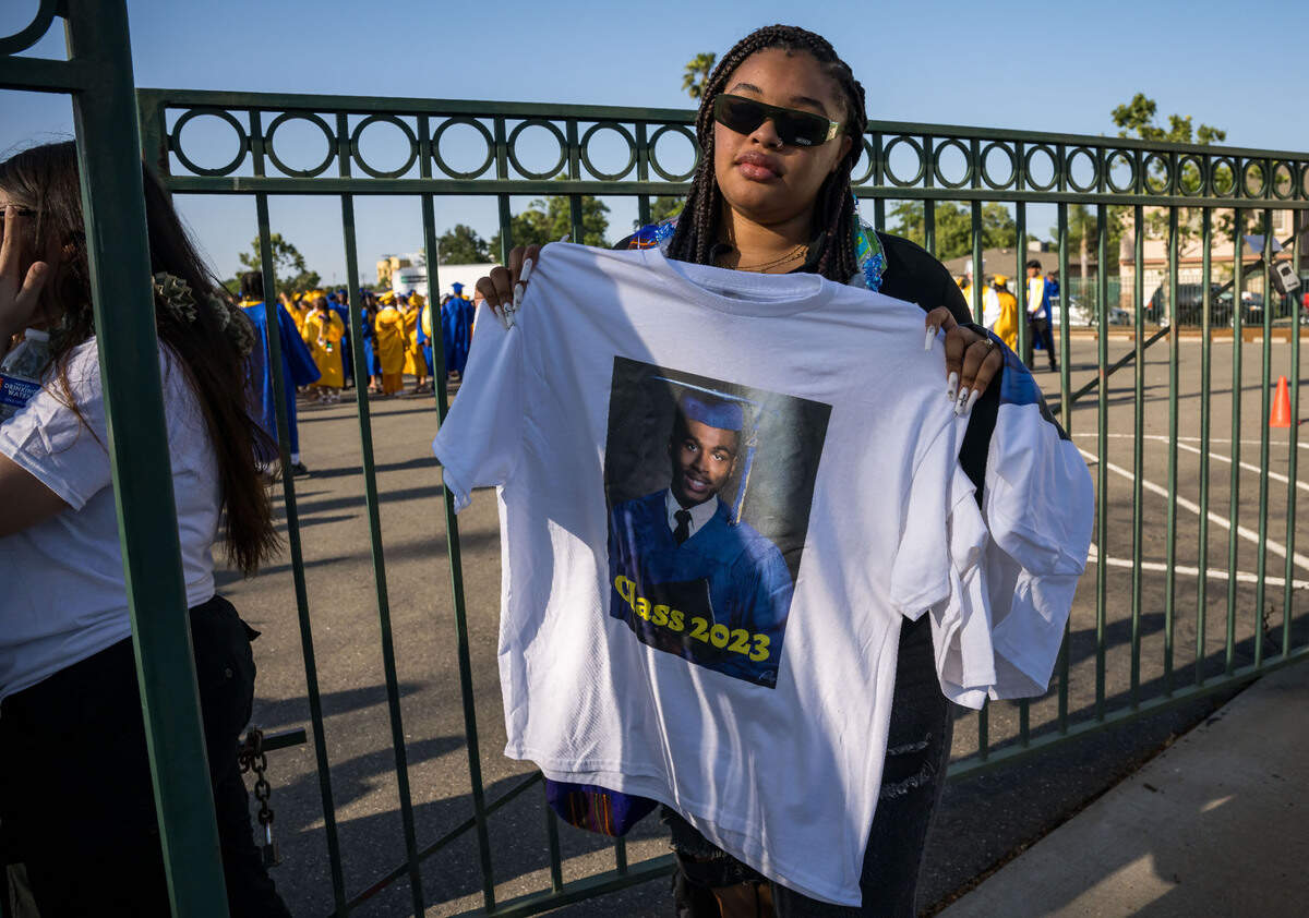 Jianna Smith, a 2022 John F. Kennedy High School graduate, holds a shirt dedicated to Bill Scott before the Grant Union High School graduation ceremony Thursday, June 1, 2023, in Sacramento’s Del Paso Heights neighborhood. Scott, an 18-year-old senior set to graduate, was killed in a North Highlands shooting the night before, authorities said.