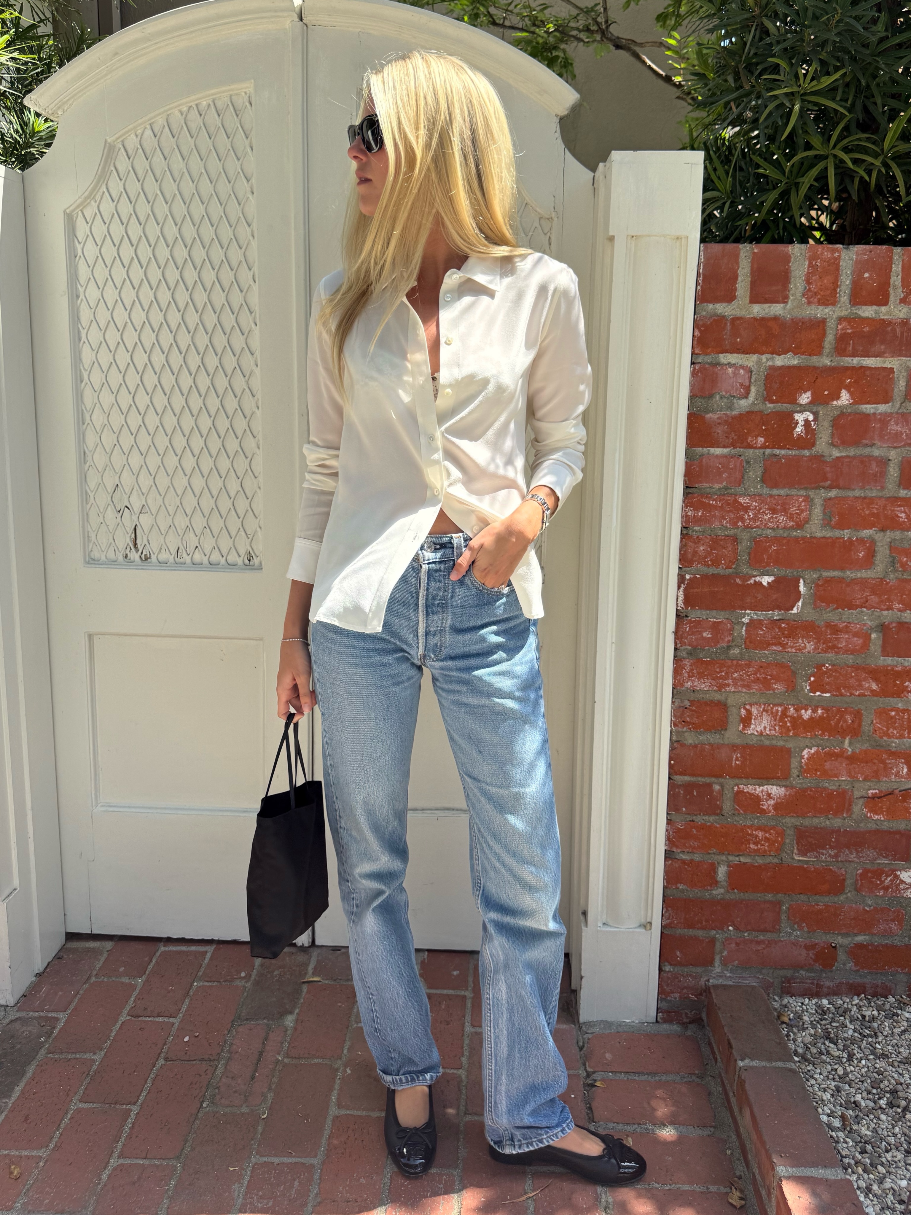 Caitlin in jeans, white shirt and ballet flats