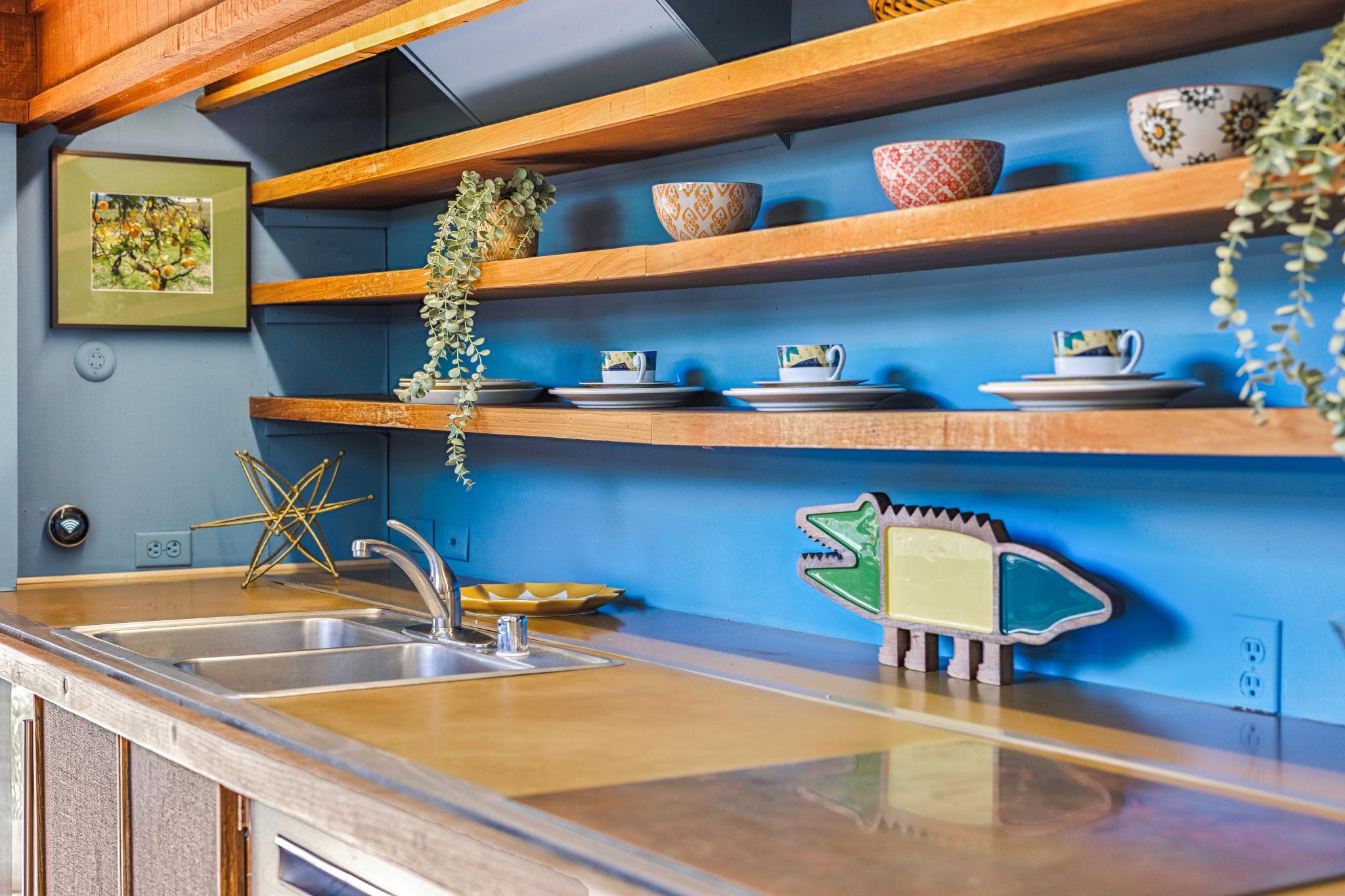 There’s a living room, bathroom and a galley kitchen with exposed wooden shelves and countertops on the first floor