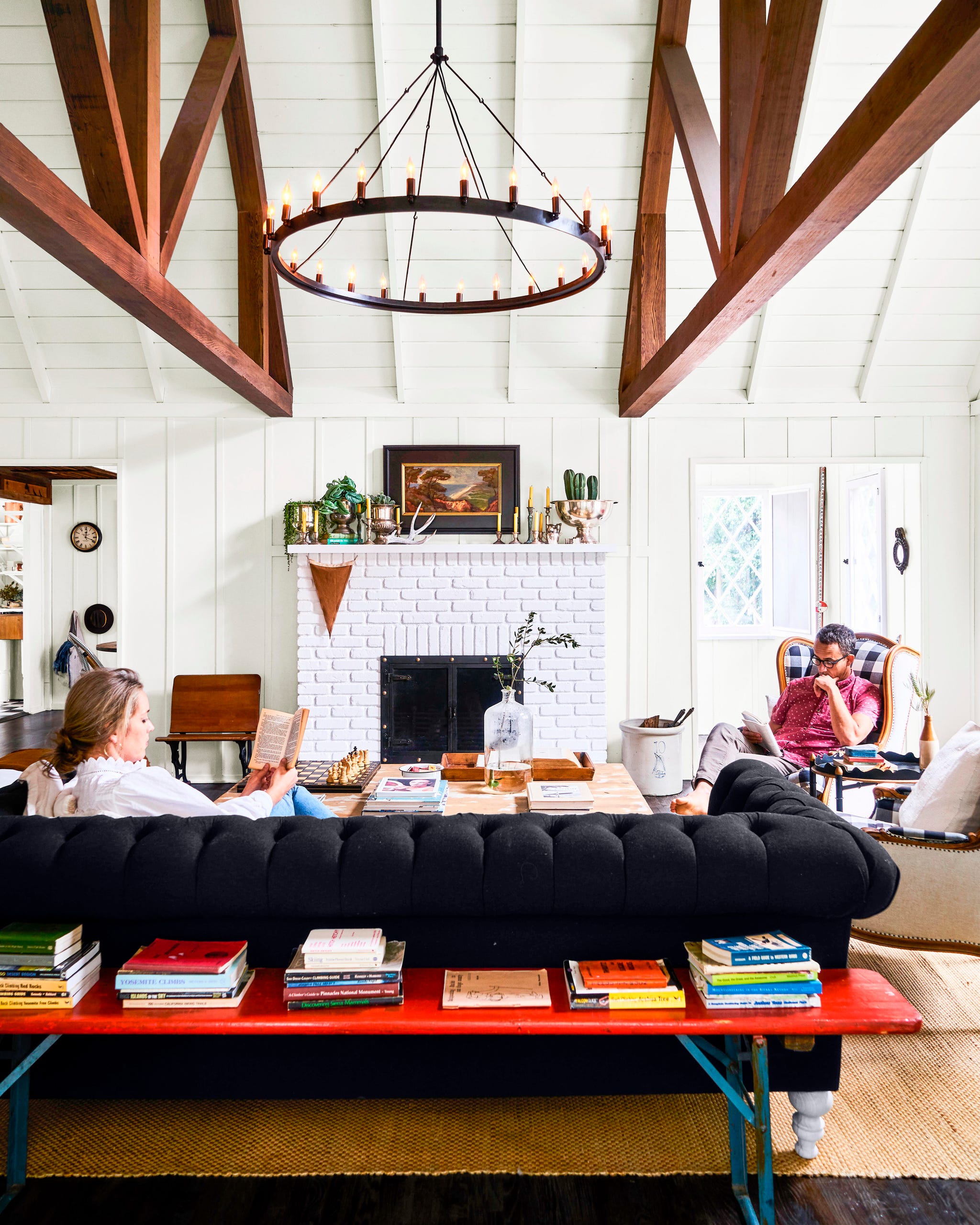 living room with high ceilings, white fireplace, and black Chesterfield sofa living room with high ceilings, white fireplace, and black Chesterfield sofa