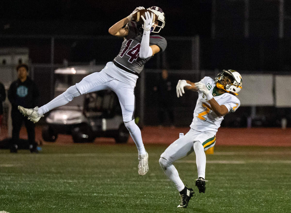 Woodcreek Timberwolves cornerback Ethan Keim (14) out jumps the Rio Americano Raiders’ Arnez Campbell (2) for an interception in the second quarter of they CIF Sac-Joaquin Division III semifinal playoff game in Roseville on Friday, Nov. 21.