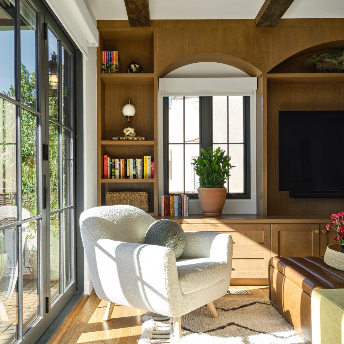a bright living room features a textured white chair with rounded lines and a decorative pillow