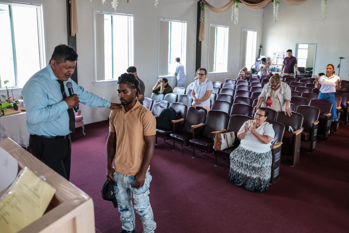 Pastor Juan Galicia welcomes and prays with new congregant Anthony Quintana during sermon at Ministerio Esperanza Church.