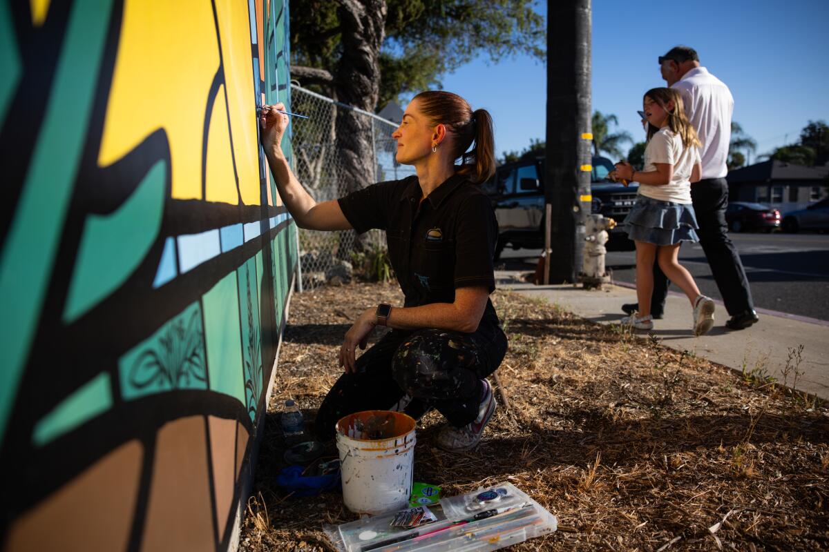 Miriam Hellmann repaints the mural outside the Pasadena Jewish Temple & Center on Thursday.