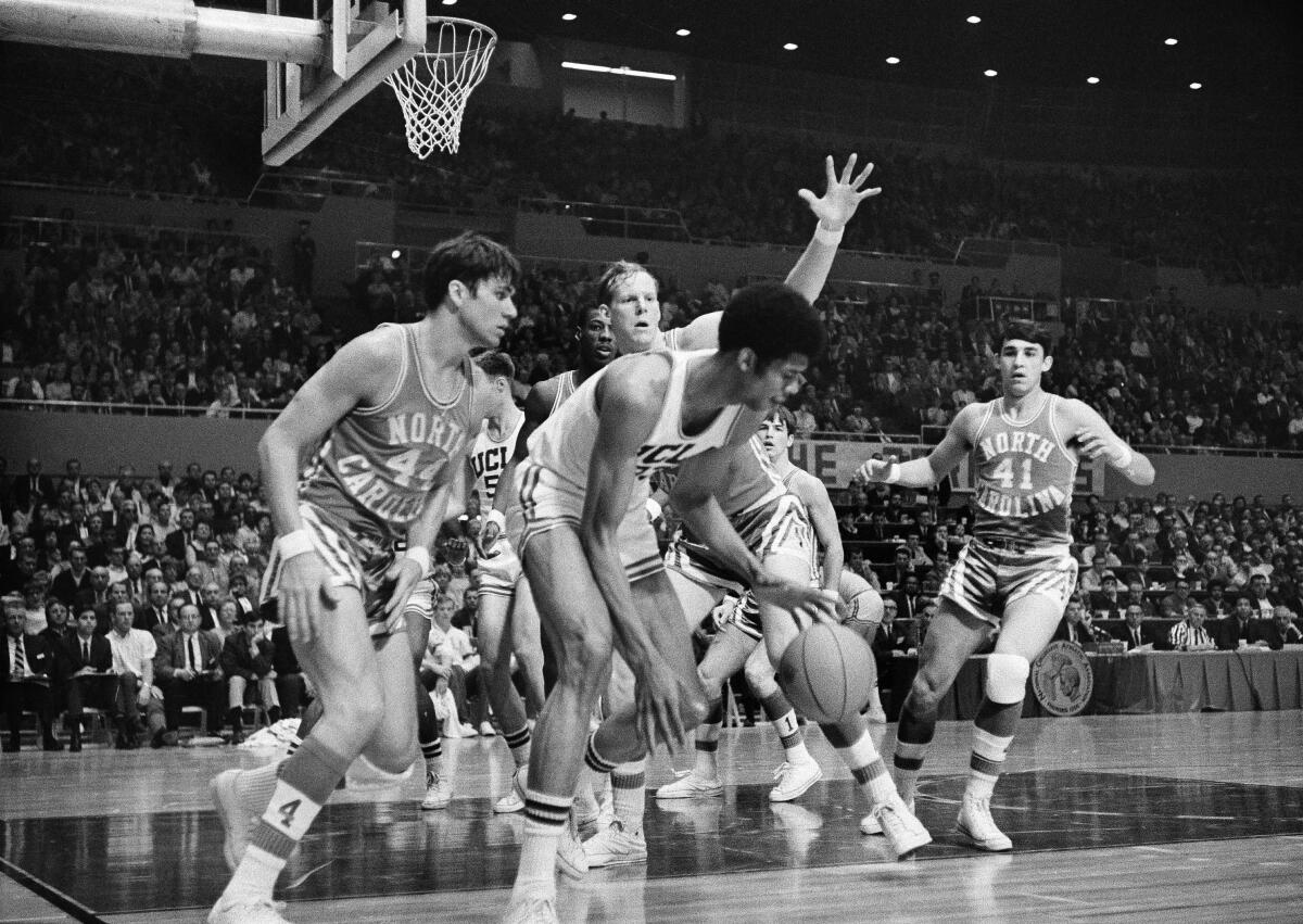 UCLA's Lew Alcindor steals the ball and dribbles away from a group of North Carolina players