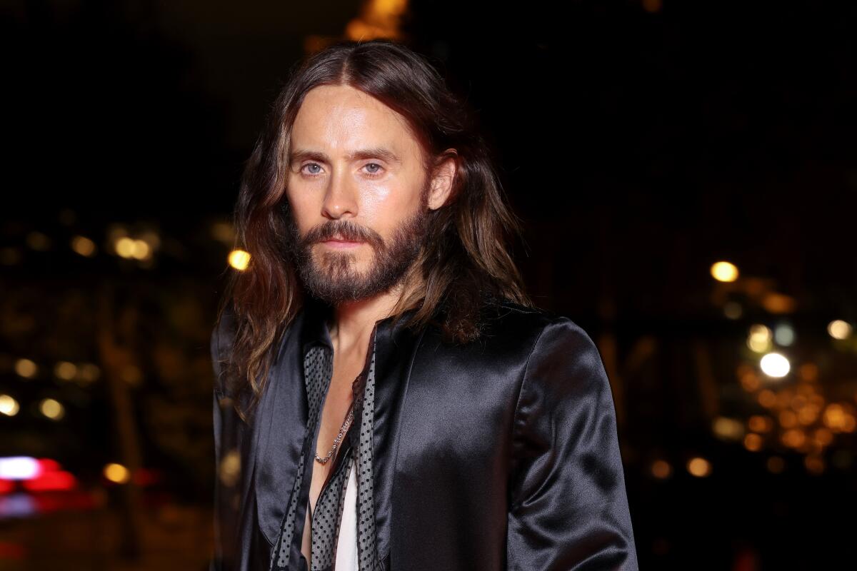Jared Leto, wearing a silk robe, looks into the camera. 