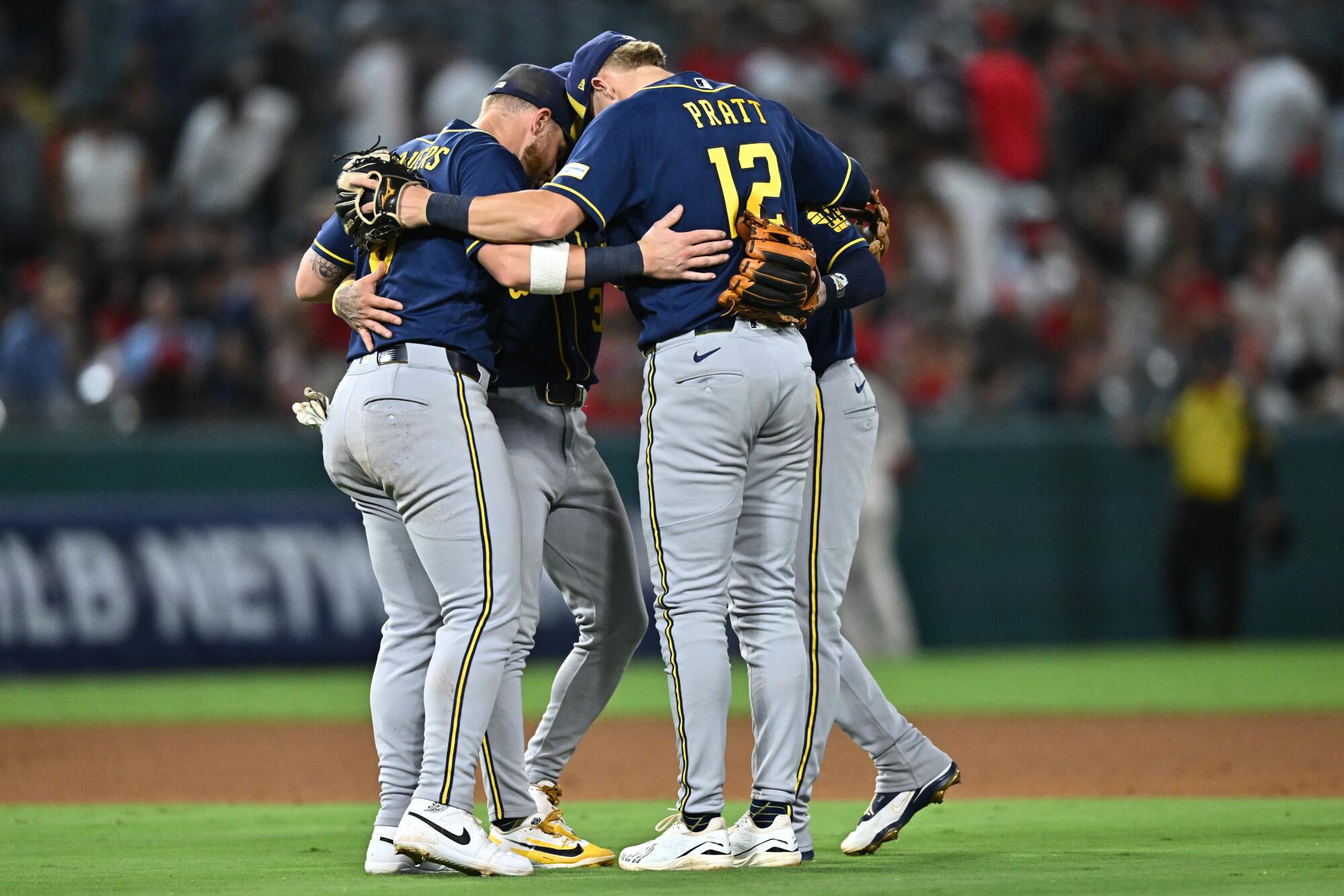 Milwaukee Brewers infield players celebrate after defeating the Angels Saturday at Angel Stadium.