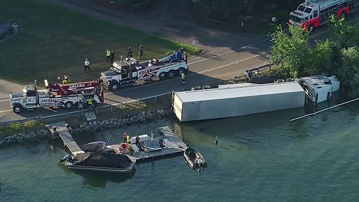 Semi overturns into Pine Lake along Pine Lake Road in Oakland County; driver suffers injury