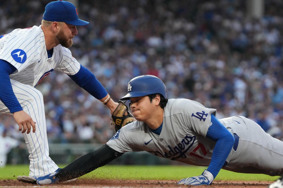Dodgers star Shohei Ohtani, right, is tagged out by Chicago Cubs first baseman Michael Busch.