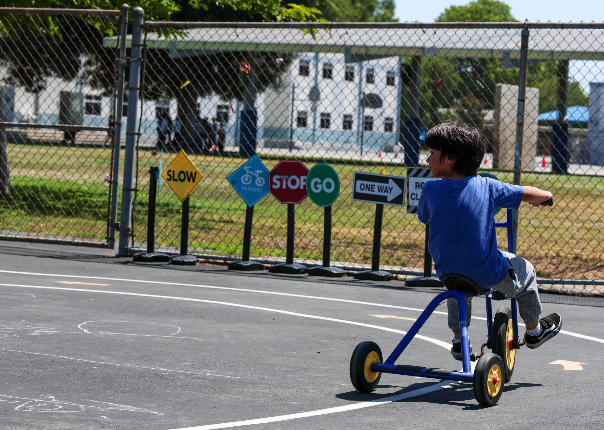 A child riding a tricycle outside