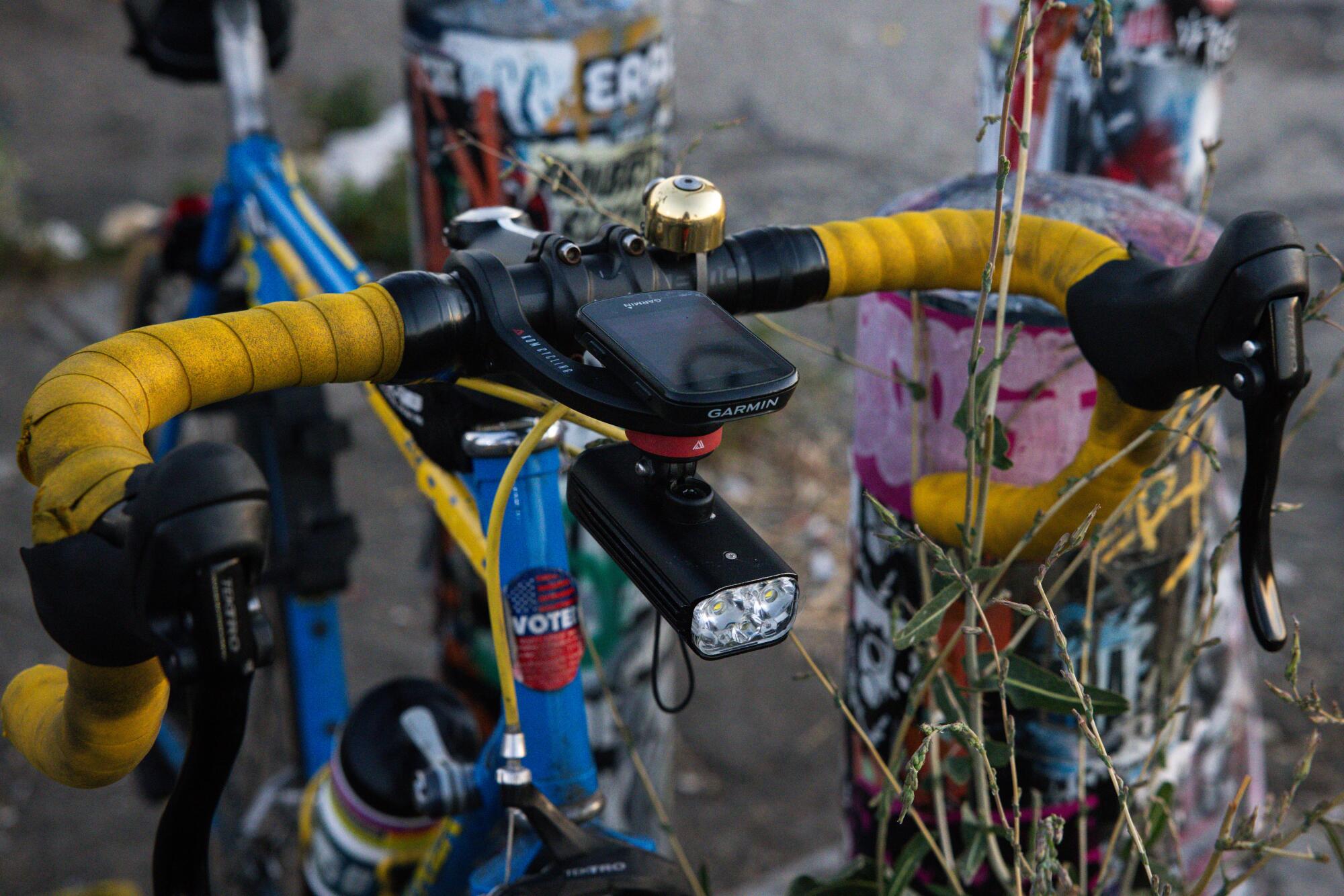 Marc Papas sets his blue and yellow 1989 Trek 400 near a graffiti post along the Los Angeles River.