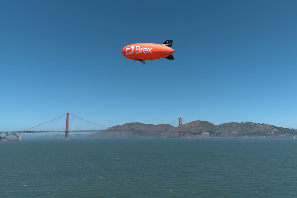 A Brex blimp flown by Buoyant flies over the San Francisco Bay.