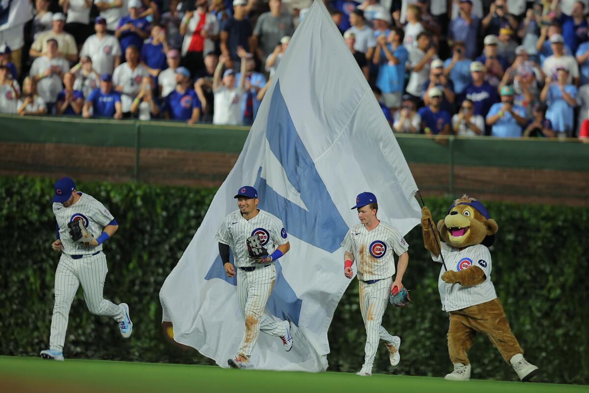 Ian Happ, left, Seiya Suzuki, middle, and Pete Crow-Armstrong run after beating the Dodgers.