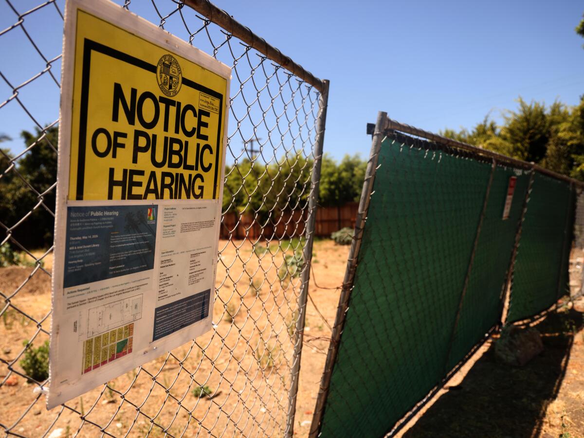 A cyclone fence in front of a lot that has been vacant for some time in the Sunset Square neighborhood in Hollywood. 